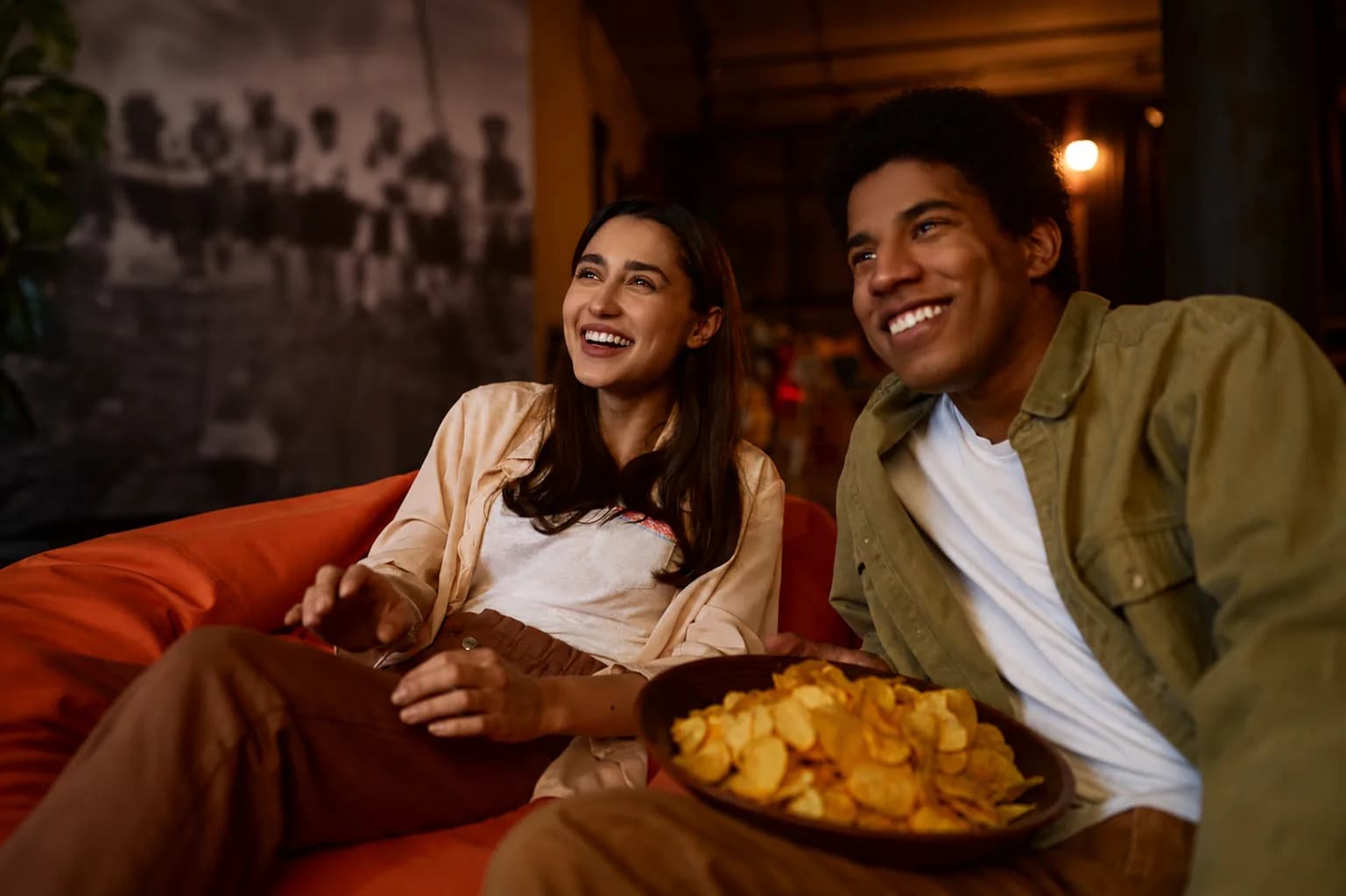 Casal assistindo televisão em casa